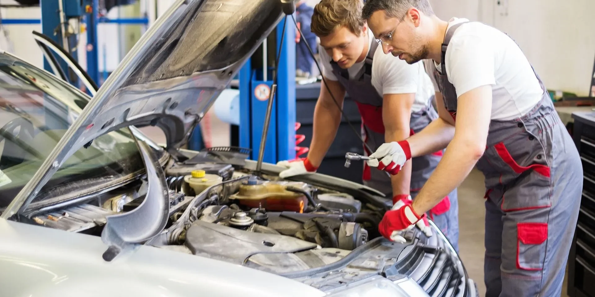 Two technicians inspecting vehicle engine